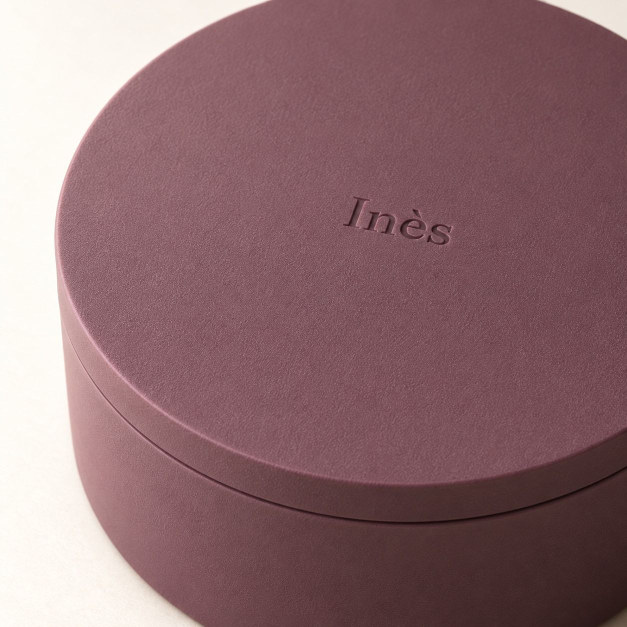 علبة دائرية برقوقية بغطاء يحمل اسم Inès
