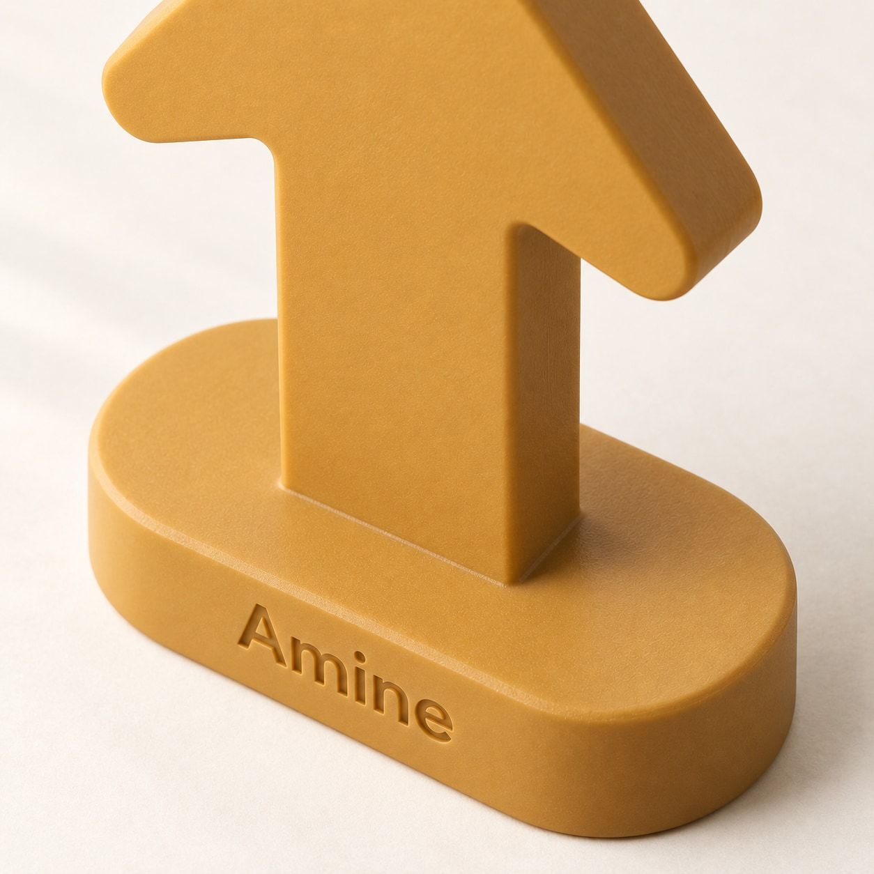 Souvenir ocre en forme de flèche avec Amine sur le socle