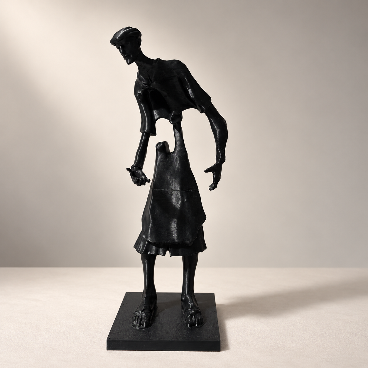 Statuette noire élancée du Guerrab de Meknès, vue de face sur socle rectangulaire.