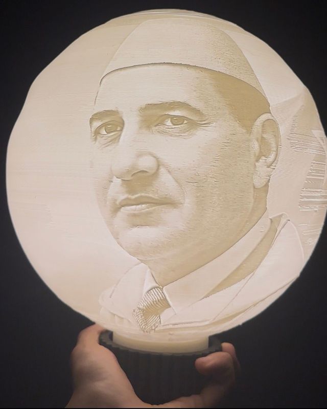 Lampe ronde lumineuse avec portrait en tons clairs et base sombre, tenue à la main ; exemple de photo personnalisée.