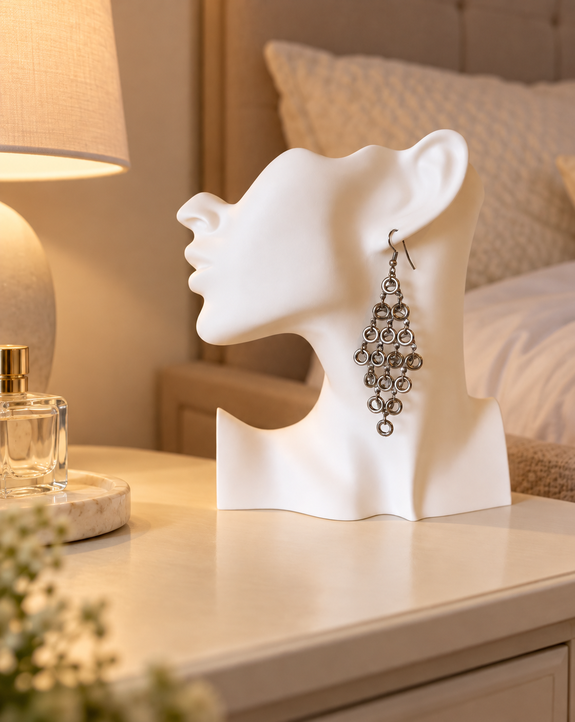 Présentoir blanc en forme de visage de profil avec une boucle d’oreille pendante.