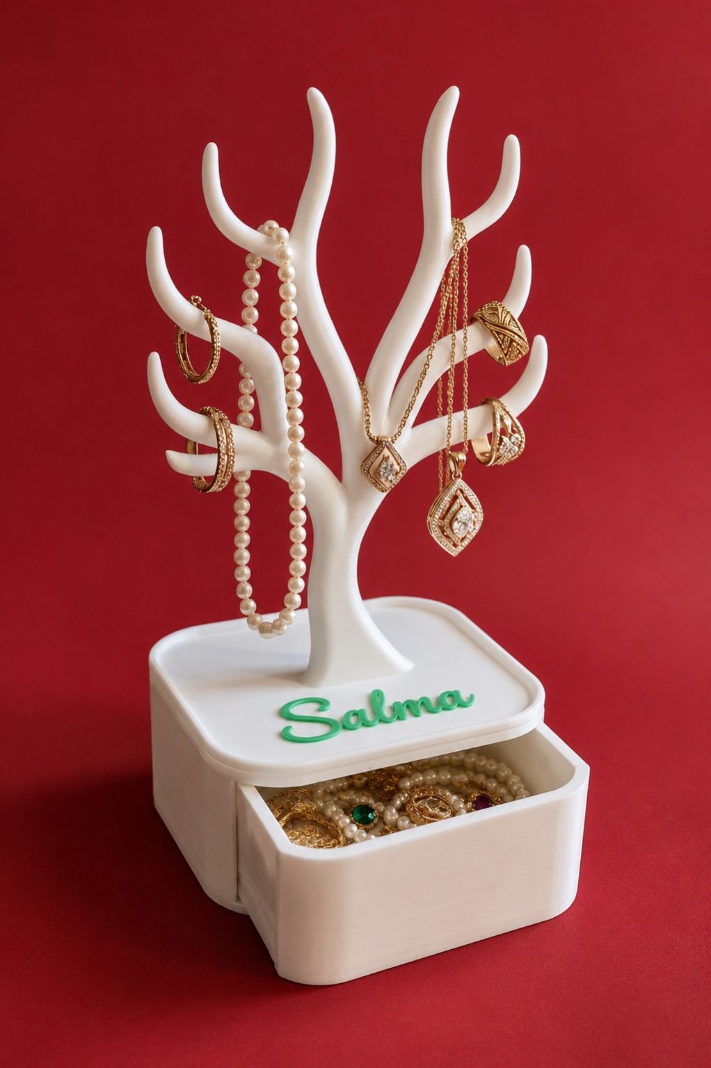 Arbre porte-bijoux blanc avec tiroir ouvert, bijoux exposés et prénom Hanane donné en exemple.