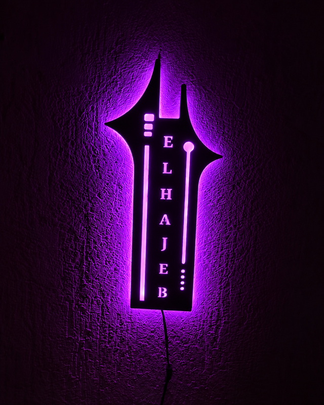 Décoration murale sombre en forme de tour, inscription verticale ELHAJEB et halo violet.