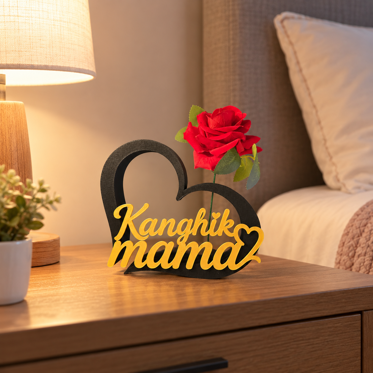 Contour de cœur noir avec message doré en caractères latins dédié à maman, présenté avec une rose rouge.