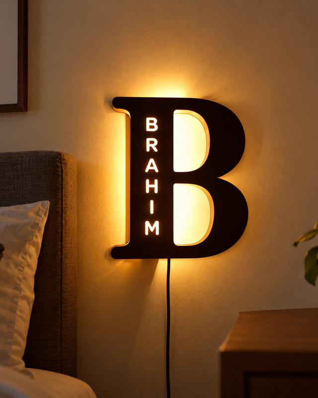 Grande lettre B sombre avec prénom Brahim lumineux en exemple et halo chaud sur le mur.