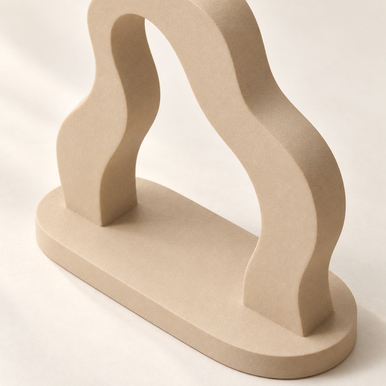 Sculpture sable en arche ondulée sur un socle ovale